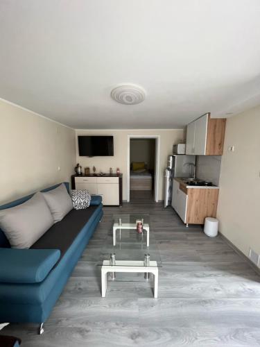 een woonkamer met een blauwe bank en een tafel bij Kuća - Na Granici in Ilok