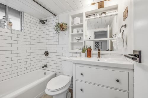 a white bathroom with a toilet and a sink and a tub at Gorgeous Serenity in Pinetop-Lakeside