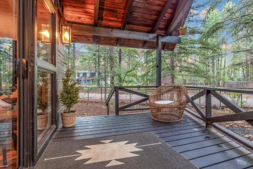 a screened in porch with a wicker chair on a deck at Gorgeous Serenity in Pinetop-Lakeside