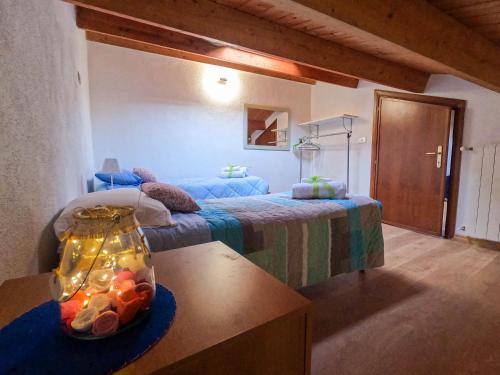 Un dormitorio con una cama y una mesa con un jarrón. en B&B Il Rifugio di Indomito Abruzzo, en LʼAquila