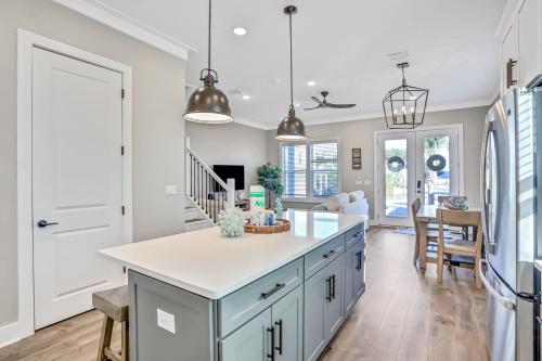 a kitchen with a blue island and a dining room at Come Sail Away in Inlet Beach