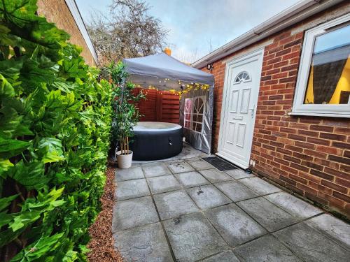 a backyard with a bath tub in a tent next to a building at Studio Apartment The Den Colnbrook in Colnbrook