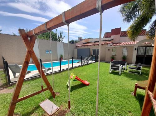 un patio trasero con un columpio y una piscina en Apartamentos Ref en Salta