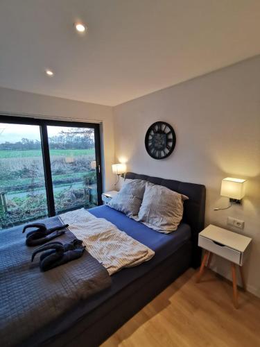 una camera da letto con un letto con un orologio sul muro di Tiny Home mit Panoramaterrasse - Ausblick ins Grüne inklusive a Wilhelmshaven