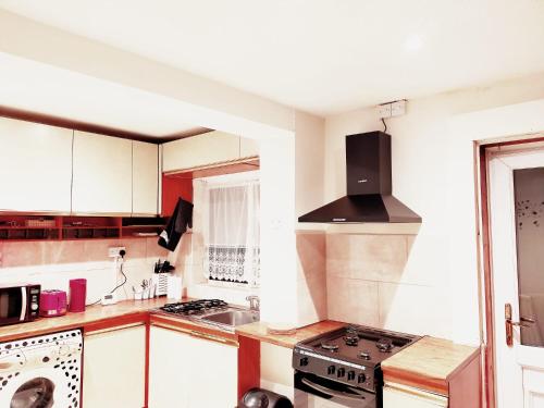 a kitchen with white cabinets and a stove top oven at EEE Home Away From Home Dudley 