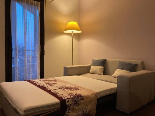 une chambre avec un lit, un canapé et une fenêtre dans l'établissement T3 - 62m2 - parking privé - métro, à Toulouse