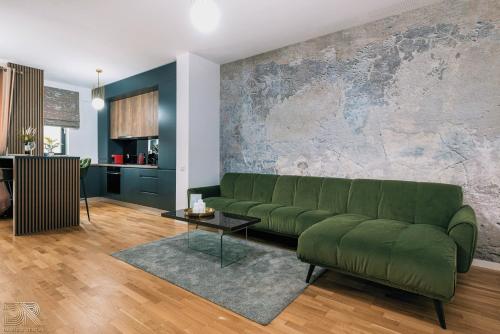 a green couch in a living room with a wall at DAVID'S RENTAL APARTMENTs in Bucharest