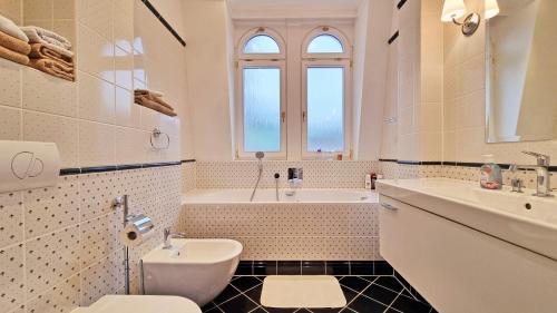 y baño con aseo, bañera y lavamanos. en Luxury apartment Diamond, en Karlovy Vary
