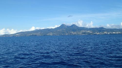 a large body of water with a city and mountains at Courbaril Résidence in Les Trois-Îlets