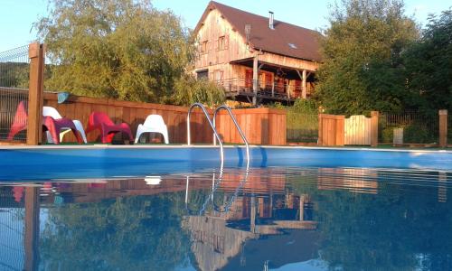 a swimming pool with chairs next to a house at Moulin D’Huile in Chaumard