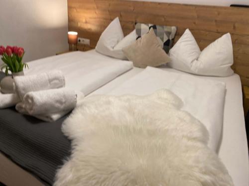 a white bed with white blankets and pillows on it at Art Apart Nomay Summercard Blick Top of Salzburg in Kaprun