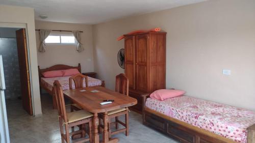 een kamer met twee bedden en een tafel en een tafel met stoelen bij Vista del Lago in Villa Carlos Paz