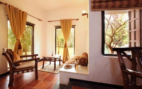 a living room with a table and two windows at Tuli Tiger Resort in Dhanwār