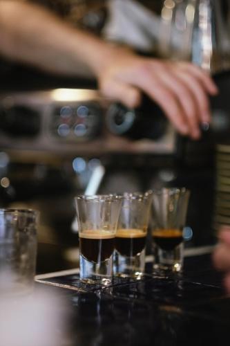 a group of glasses on a table with a bartender at Laburnum Guest House at Bistro En Glaze in Wylam