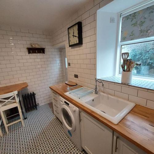 Lovely 1 Bed house in Largs, North Ayrshire في لارغس: مطبخ مع مغسلة وغسالة ملابس