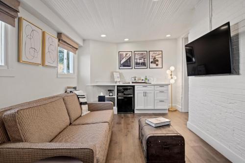 a living room with a couch and a tv at Bespoke Inn Flagstaff in Flagstaff