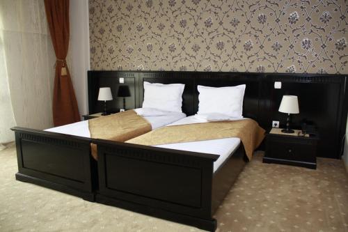 a bedroom with a large bed with white pillows at Hotel Imperium in Suceava