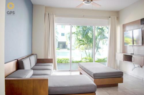 a living room with two beds and a large window at hermoso depa con vista a la marina by G P S rentas in Mazatlán