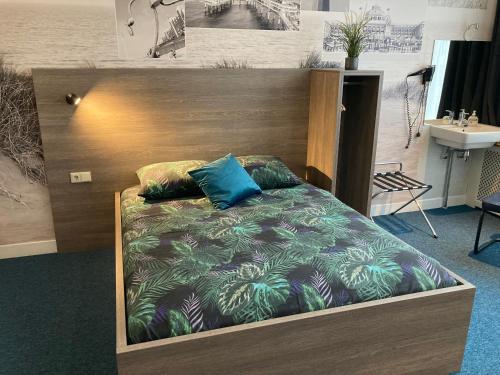 een bed met een houten hoofdeinde in een kamer bij Hotel Poseidon in Scheveningen