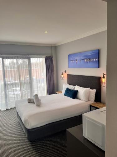 a hotel room with a large bed and a large window at Merewether Motel in Newcastle