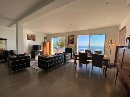 a large living room with a table and chairs at Vue mer.Tranquilité.Cap d'Ail à 10 mn de MONACO in Cap d'Ail