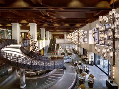 a large lobby with a spiral staircase in a building at Sofitel Philippine Plaza Manila in Manila