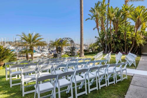 a row of white chairs on a lawn with a marina at Best Western PLUS Island Palms Hotel & Marina in San Diego