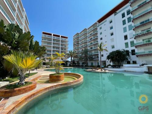 a large swimming pool with palm trees and buildings at hermoso depa con vista a la marina by G P S rentas in Mazatlán