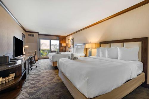 a hotel room with two beds and a flat screen tv at Best Western PLUS Island Palms Hotel & Marina in San Diego