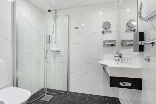 a white bathroom with a shower and a sink at Best Western Hotel Corallen in Oskarshamn