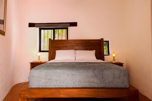 1 dormitorio con 1 cama de madera y 2 lámparas en las mesas en Villa 19 habitación #2 en Guanajuato