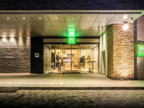 an entrance to a building at night with a green light at Ibis Styles Sapporo in Sapporo