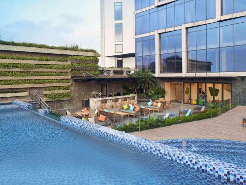 a hotel with a swimming pool in front of a building at Novotel Hanoi Thai Ha in Hanoi