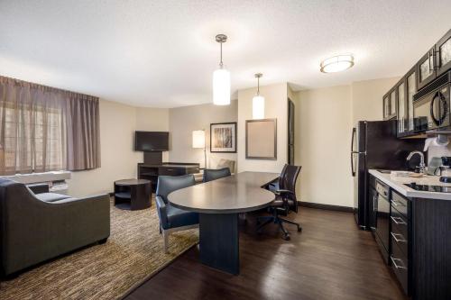 a living room with a table and chairs in a hotel room at Sonesta Simply Suites Albuquerque Midtown in Albuquerque