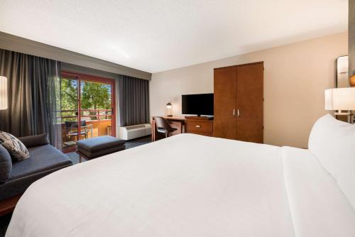 a hotel room with a large bed and a television at Sonesta Select San Jose Airport in San Jose