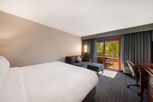 a hotel room with a bed and a balcony at Sonesta Select San Jose Airport in San Jose