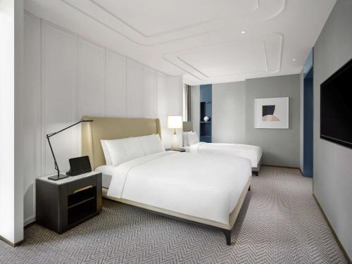 a hotel room with two beds and a television at Sofitel Ambassador Seoul Hotel & Serviced Residences in Seoul