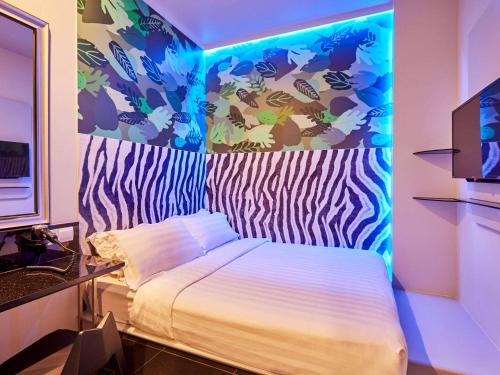 una camera con letto e luce blu di ibis budget Singapore Bugis a Singapore