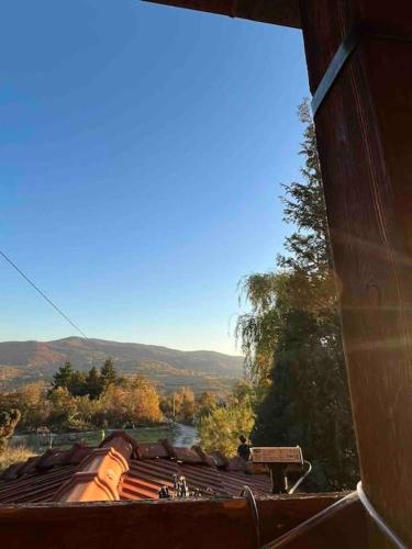 a view of a roof of a building with mountains in the background at Cottage House Official in Niš