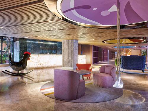 a lobby with purple furniture and a table and chairs at Mondrian Seoul Itaewon in Seoul