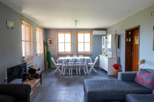 a living room with a couch and a table and chairs at Cottage House Official in Niš