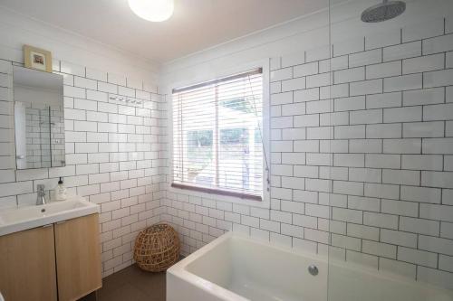 a white bathroom with a tub and a sink at Palm Beach House - sleeps 10 - spacious in Point Lookout