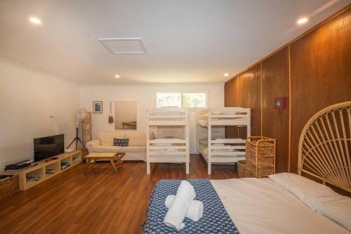 a bedroom with two bunk beds and a living room at Palm Beach House - sleeps 10 - spacious in Point Lookout
