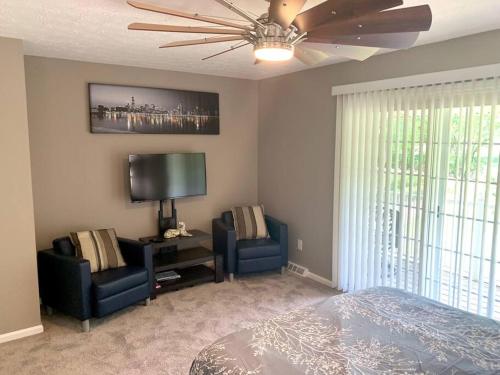 a bedroom with two chairs and a bed and a television at E. Turkeyfoot Whole House in Akron
