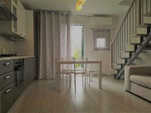 a kitchen with a table and chairs and a staircase at Apartment in Albarella 42379 in Palazzo Vianello