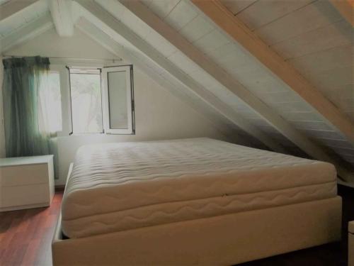 a bedroom with a large bed in a attic at Apartment in Albarella 42379 in Palazzo Vianello