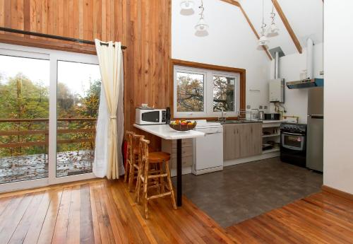 a kitchen with a table and chairs in a room at Chile Wild - Las Vertientes in Malalcahuello