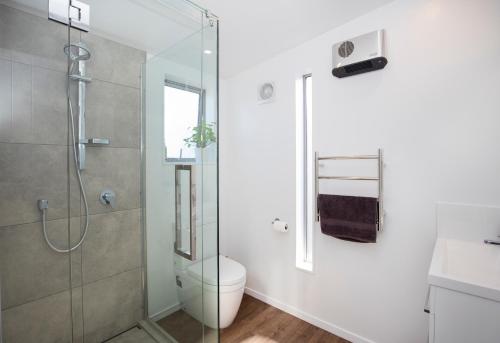 a bathroom with a shower and a toilet and a sink at Waterfront Retreat - Westport Self-Contained Unit in Westport