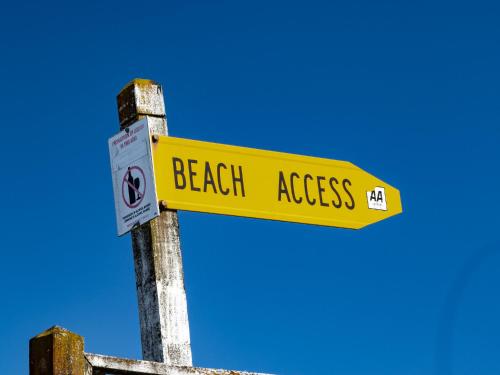 a yellow street sign with the words beach access at Pohara Beach Escape - Pohara Beach Holiday Home in Pohara