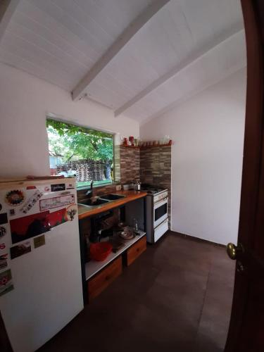 cocina con nevera blanca y ventana en casita para dos! en Lago Puelo
